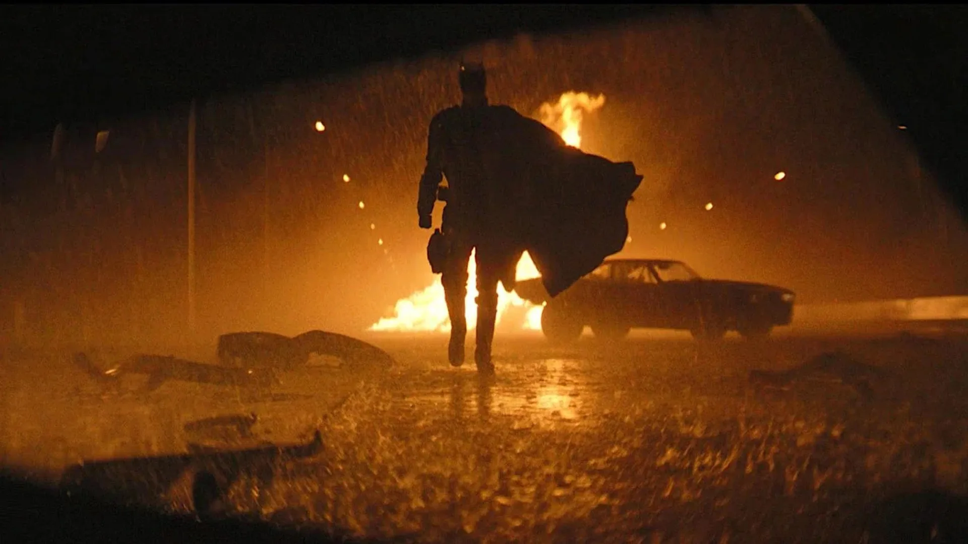 The Batman demanda: Batman caminando bajo la lluvia con un carro en llamas a sus espaldas