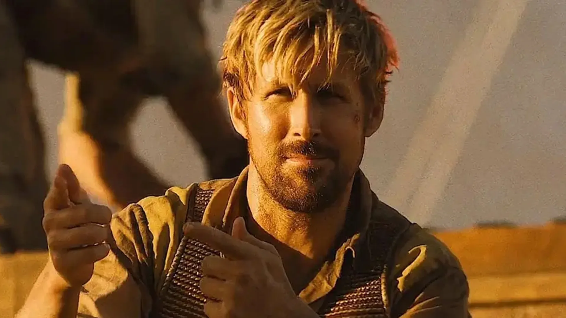Ryan Gosling sonriente bajo el sol apuntando con los dedos